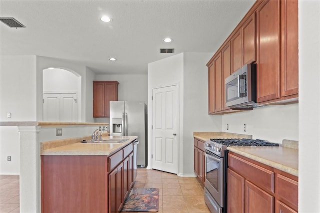 232 Wells Bnd, Hutto, TX 78634 - kitchen featuring appliances with stainless steel finishes, a sink, recessed lighting, light tile patterned floors, and light countertops