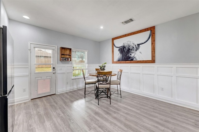 107 Denton Dr, Hutto, TX 78634 - dining area with a decorative wall, a wainscoted wall, light wood-style floors, and recessed lighting