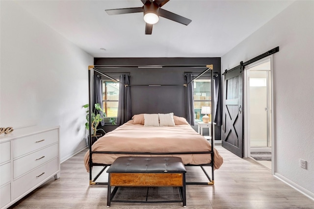 107 Denton Dr, Hutto, TX 78634 - bedroom with light wood finished floors, a barn door, and a ceiling fan