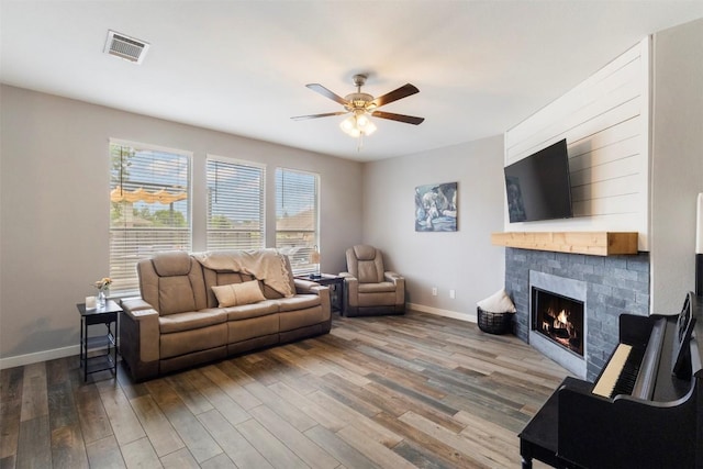 320 Ranier Ln, Round Rock, TX 78665 - living area featuring a ceiling fan, wood finished floors, a warm lit fireplace, and baseboards