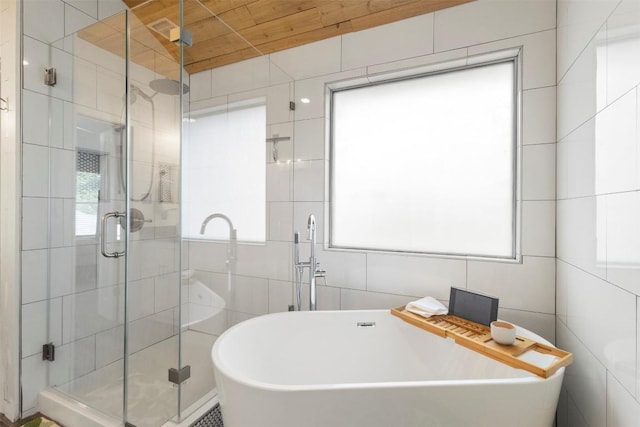 320 Ranier Ln, Round Rock, TX 78665 - bathroom featuring tile walls, a soaking tub, and a stall shower
