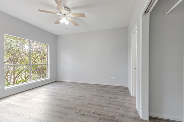 2450 Wickersham Ln Unit 1601, Austin, TX 78741 - spare room featuring light wood-style floors, a ceiling fan, and baseboards