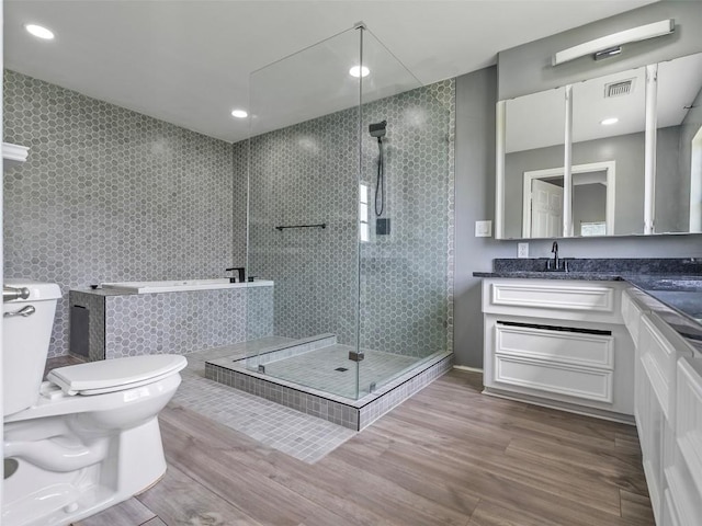 2939 Jeffcote Rd, Conroe, TX 77303 - bathroom with vanity, wood finished floors, toilet, a stall shower, and recessed lighting