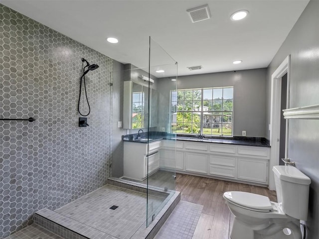 2939 Jeffcote Rd, Conroe, TX 77303 - bathroom with toilet, vanity, tiled shower, wood finished floors, and recessed lighting