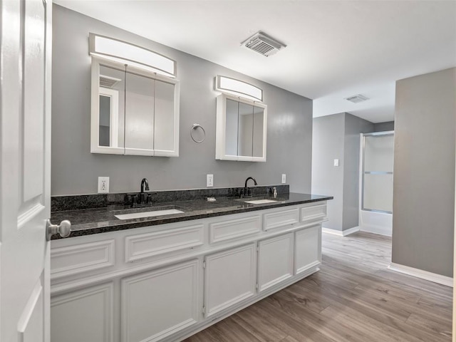 2939 Jeffcote Rd, Conroe, TX 77303 - full bathroom featuring double vanity, wood finished floors, baseboards, and shower / bathtub combination