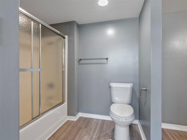 2939 Jeffcote Rd, Conroe, TX 77303 - bathroom featuring wood finished floors, toilet, baseboards, and combined bath / shower with glass door