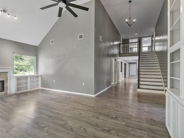 2939 Jeffcote Rd, Conroe, TX 77303 - unfurnished living room featuring high vaulted ceiling, a premium fireplace, a ceiling fan, stairway, and baseboards