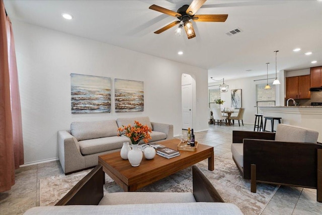 16513 Brogan Ln, Pflugerville, TX 78660 - living area with a ceiling fan, recessed lighting, baseboards, light tile patterned floors, and arched walkways