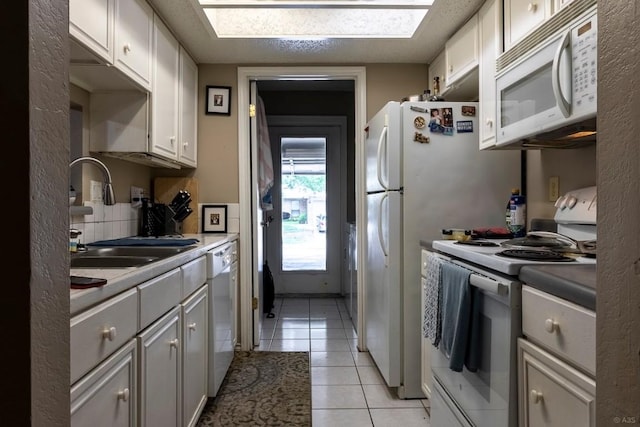 2625 Gwendolyn Ln, Austin, TX 78748 - kitchen with white appliances, a sink, light tile patterned flooring, tasteful backsplash, and a skylight