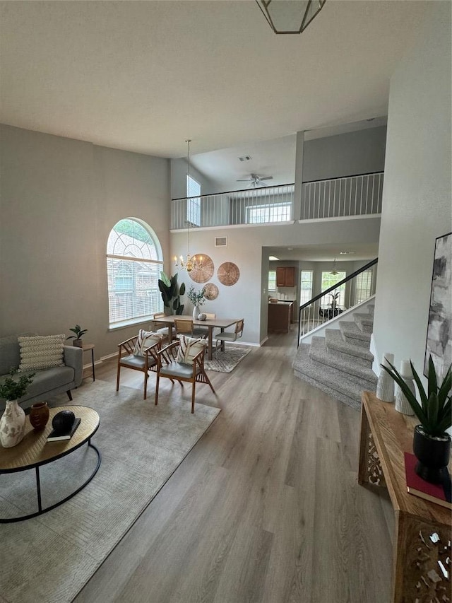 10301 Beard Ave, Austin, TX 78748 - living room with stairway, wood finished floors, healthy amount of natural light, baseboards, and a towering ceiling