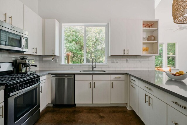 3001 Del Curto Rd Unit 14, Austin, TX 78704 - kitchen featuring stainless steel appliances, finished concrete floors, open shelves, a sink, and backsplash
