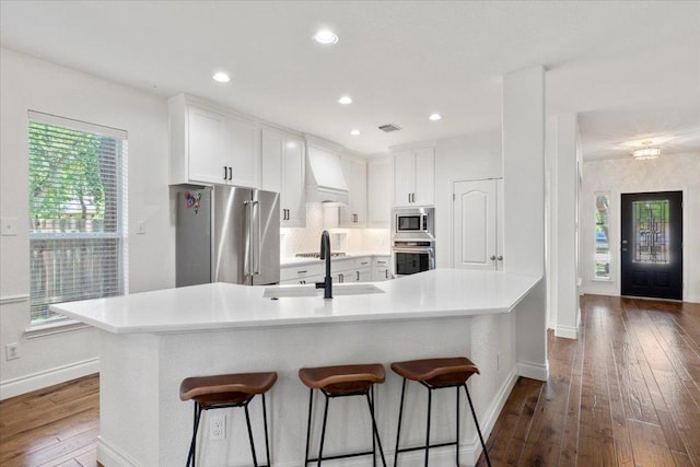 2713 Vaquera Ct, Round Rock, TX 78681 - kitchen with stainless steel appliances, dark wood-type flooring, a breakfast bar, white cabinetry, and recessed lighting