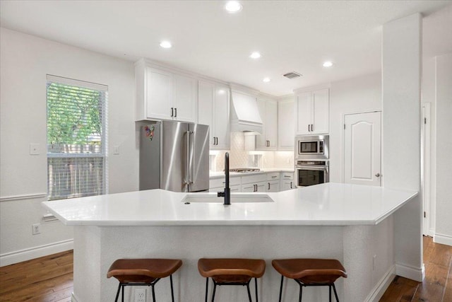 2713 Vaquera Ct, Round Rock, TX 78681 - kitchen featuring stainless steel appliances, a breakfast bar, dark wood-style floors, white cabinetry, and recessed lighting