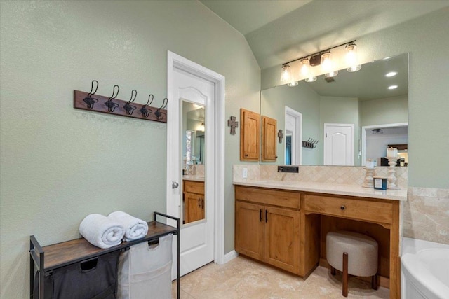 2713 Vaquera Ct, Round Rock, TX 78681 - full bath featuring a garden tub, vanity, lofted ceiling, decorative backsplash, and tile patterned flooring