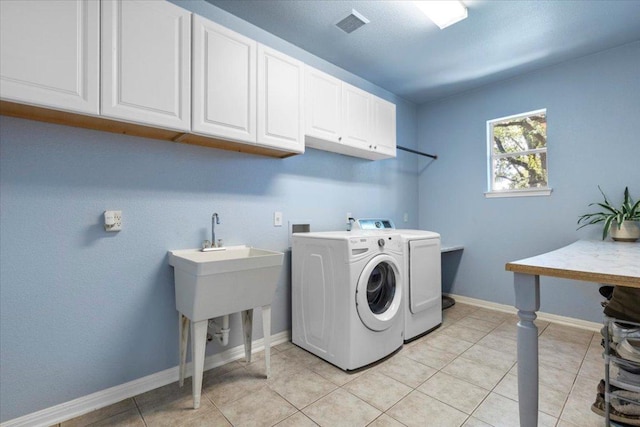 2713 Vaquera Ct, Round Rock, TX 78681 - laundry area with cabinet space, washer and dryer, and light tile patterned floors