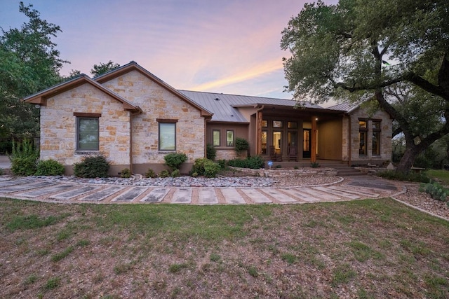 116 Horseshoe Dr, Dripping Springs, TX 78620 - back of house featuring a standing seam roof, stone siding, metal roof, and a lawn