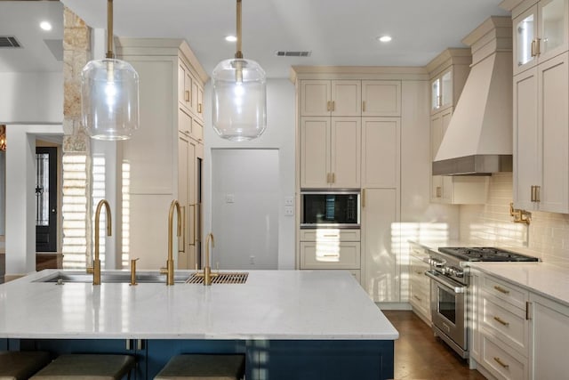 116 Horseshoe Dr, Dripping Springs, TX 78620 - kitchen with high end range, premium range hood, built in microwave, a breakfast bar area, and light stone countertops