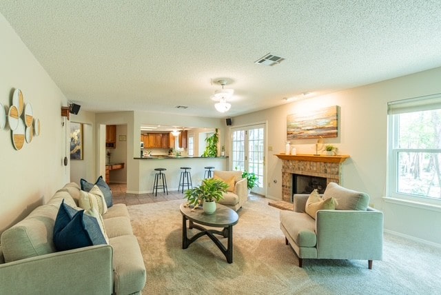 1202 Tremont Dr, Cedar Park, TX 78613 - living area featuring a textured ceiling, a brick fireplace, and light carpet