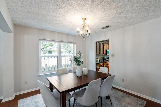 1202 Tremont Dr, Cedar Park, TX 78613 - dining area with a chandelier, dark wood-style flooring, a textured ceiling, and baseboards