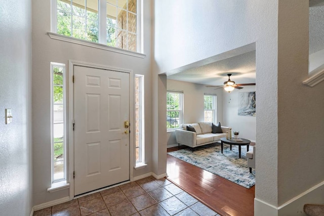 1202 Tremont Dr, Cedar Park, TX 78613 - entryway with a towering ceiling, tile patterned floors, a textured wall, ceiling fan, and baseboards