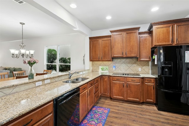 308 Hills Of Texas Trl, Georgetown, TX 78633 - kitchen with black appliances, a sink, wood finished floors, light stone countertops, and tasteful backsplash