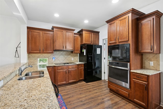 308 Hills Of Texas Trl, Georgetown, TX 78633 - kitchen featuring black appliances, a sink, dark wood-type flooring, light stone countertops, and decorative backsplash