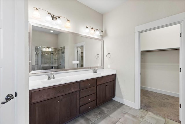 18716 Waltz Ct, Austin, TX 78738 - bathroom featuring a spacious closet, double vanity, a stall shower, baseboards, and tile patterned flooring