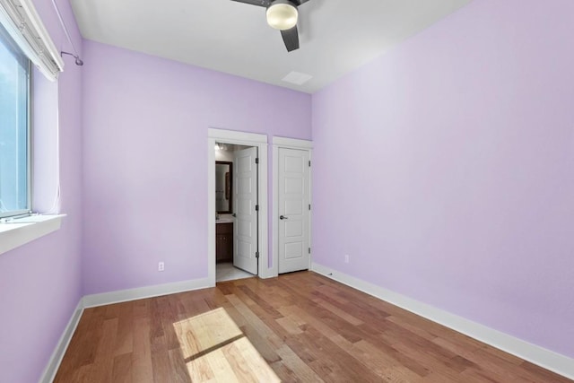 18716 Waltz Ct, Austin, TX 78738 - unfurnished bedroom with wood finished floors, baseboards, connected bathroom, and ceiling fan
