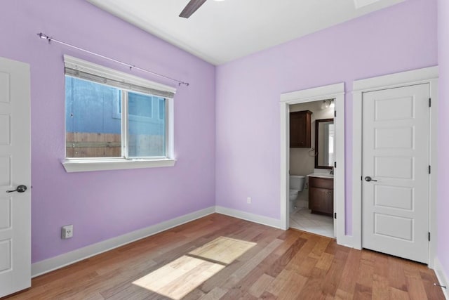 18716 Waltz Ct, Austin, TX 78738 - unfurnished bedroom with wood finished floors, baseboards, ensuite bath, and ceiling fan