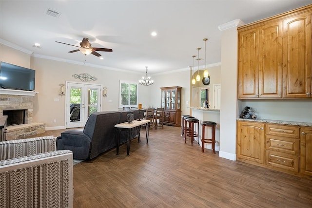 108 Kaliu Ct, Bastrop, TX 78602 - living room featuring a ceiling fan, a fireplace, ornamental molding, dark wood-style floors, and recessed lighting