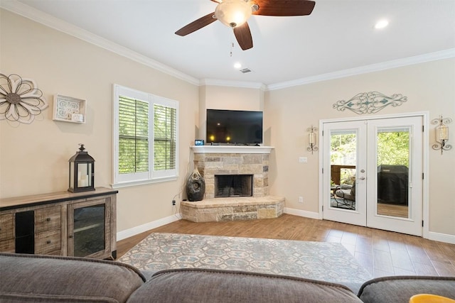108 Kaliu Ct, Bastrop, TX 78602 - living room with healthy amount of natural light, crown molding, wood finished floors, a ceiling fan, and a fireplace