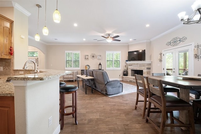108 Kaliu Ct, Bastrop, TX 78602 - dining space with a fireplace, recessed lighting, a ceiling fan, ornamental molding, and wood finished floors
