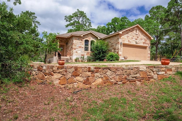 108 Kaliu Ct, Bastrop, TX 78602 - ranch-style house featuring stone siding, an attached garage, and concrete driveway
