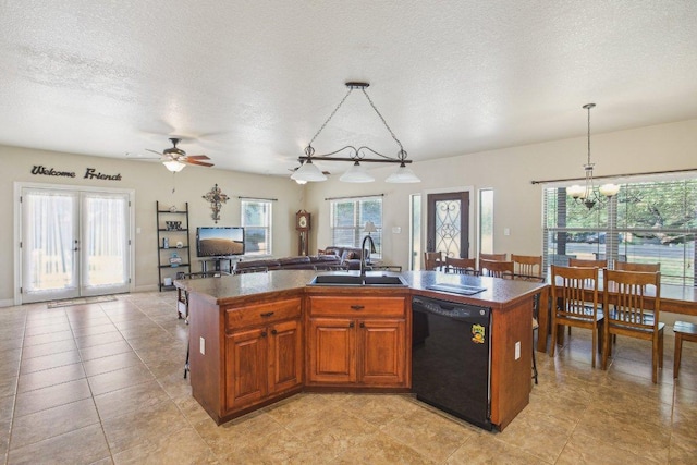 600 Augusta Cir N, Point Venture, TX 78645 - kitchen with dishwasher, a sink, dark countertops, healthy amount of natural light, and a textured ceiling