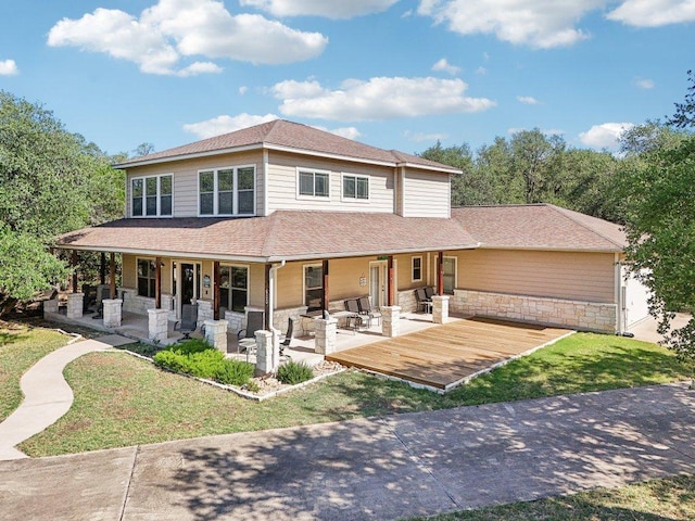 600 Augusta Cir N, Point Venture, TX 78645 - farmhouse-style home featuring a front lawn, stone siding, a shingled roof, and a wooden deck