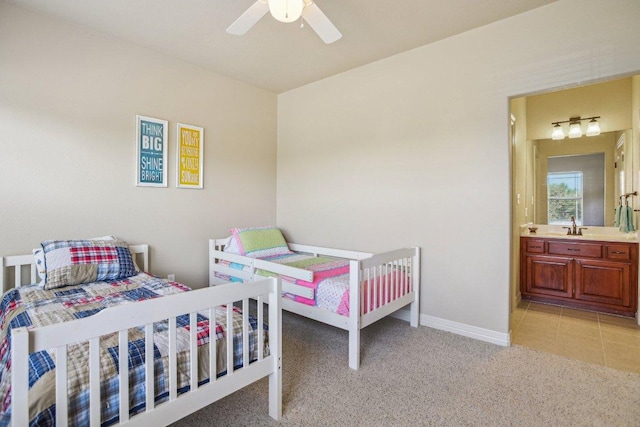 600 Augusta Cir N, Point Venture, TX 78645 - bedroom featuring light colored carpet, baseboards, ensuite bathroom, and ceiling fan