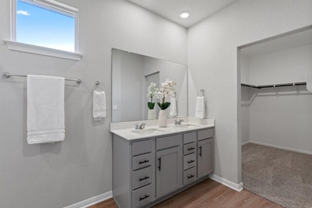 632 Otto Ave, Georgetown, TX 78626 - bathroom featuring double vanity, a spacious closet, and wood finished floors