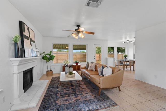 14708 Single Trce, Austin, TX 78728 - living room featuring a ceiling fan, a fireplace with raised hearth, and light tile patterned floors