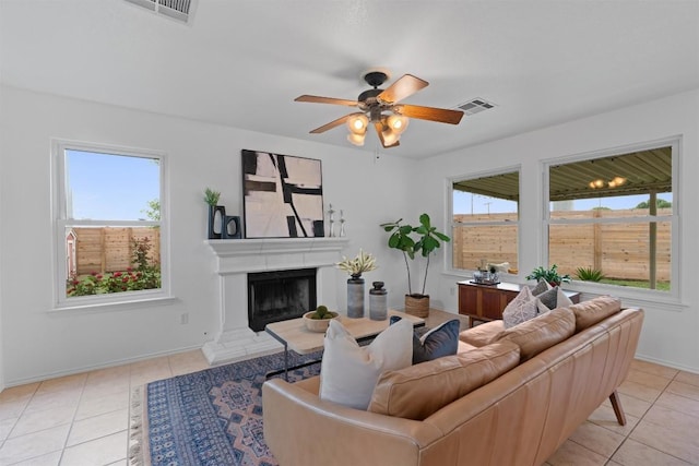 14708 Single Trce, Austin, TX 78728 - living room with light tile patterned floors, ceiling fan, baseboards, and a fireplace with raised hearth