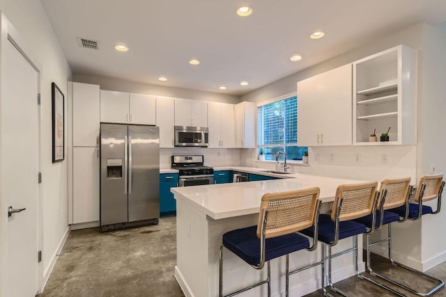 3001 Del Curto Rd Unit 11, Austin, TX 78704 - kitchen with stainless steel appliances, a sink, a peninsula, a kitchen breakfast bar, and baseboards