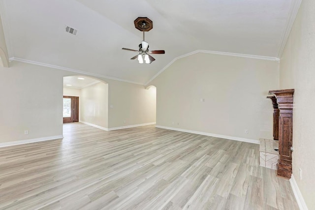 903 N Neans Dr, Austin, TX 78758 - unfurnished living room featuring arched walkways, a ceiling fan, vaulted ceiling, ornamental molding, and light wood-type flooring