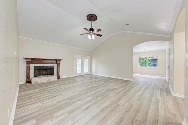 903 N Neans Dr, Austin, TX 78758 - unfurnished living room featuring a ceiling fan, light wood finished floors, plenty of natural light, lofted ceiling, and arched walkways