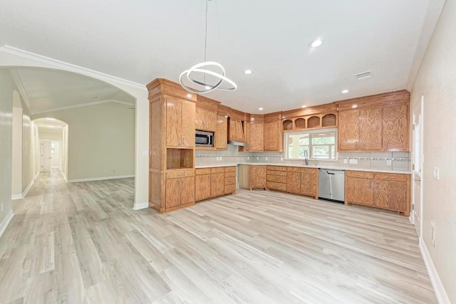 903 N Neans Dr, Austin, TX 78758 - kitchen with stainless steel appliances, light countertops, brown cabinetry, light wood finished floors, and tasteful backsplash