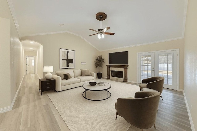903 N Neans Dr, Austin, TX 78758 - living room featuring wood finished floors, ceiling fan, arched walkways, vaulted ceiling, and a fireplace