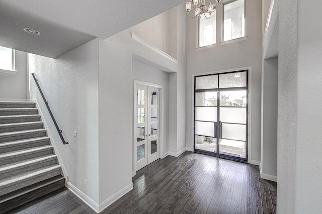 1916 Port Bari Ct, Leander, TX 78641 - foyer featuring a chandelier, dark wood-type flooring, stairs, baseboards, and a towering ceiling