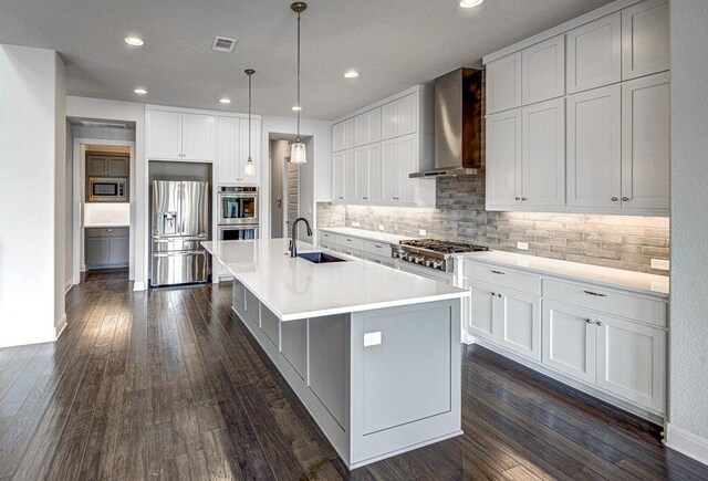 1916 Port Bari Ct, Leander, TX 78641 - kitchen featuring stainless steel appliances, a sink, wall chimney range hood, an island with sink, and backsplash