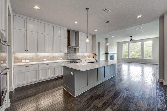1916 Port Bari Ct, Leander, TX 78641 - kitchen with wall chimney exhaust hood, a sink, white cabinetry, backsplash, and recessed lighting