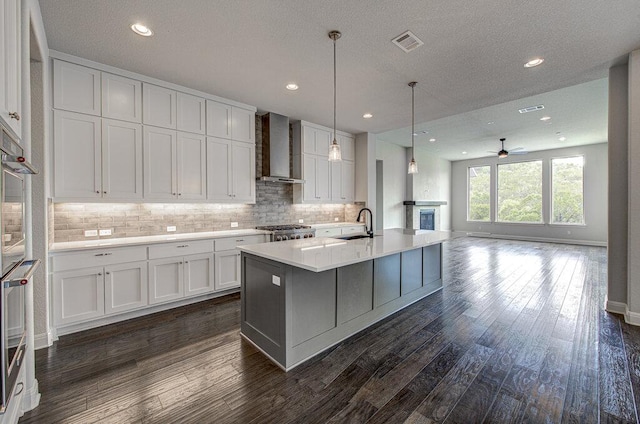 1916 Port Bari Ct, Leander, TX 78641 - kitchen with wall chimney exhaust hood, a sink, white cabinetry, decorative backsplash, and recessed lighting