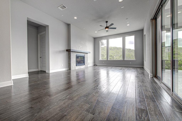 1916 Port Bari Ct, Leander, TX 78641 - unfurnished living room featuring ceiling fan, dark wood-type flooring, a tiled fireplace, recessed lighting, and baseboards