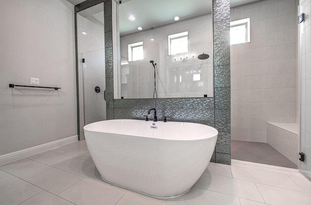 1916 Port Bari Ct, Leander, TX 78641 - full bathroom featuring a freestanding tub, a walk in shower, tile patterned floors, and baseboards